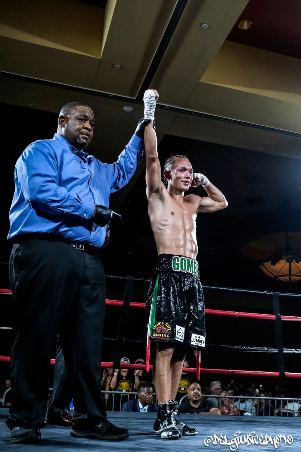 Miguel Gomez, Coach at Music City Boxing, with his hand raised after a win
